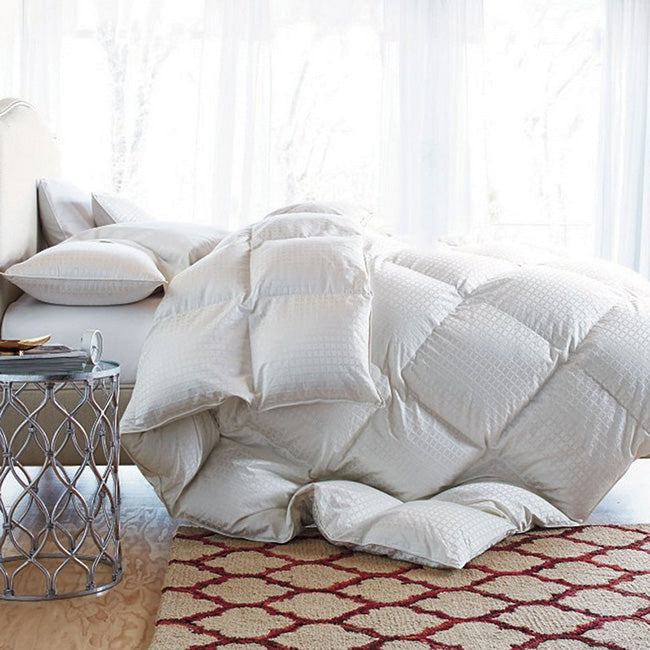 Beautifully made bed with quality down comforter and layered bedding in a well-designed bedroom interior