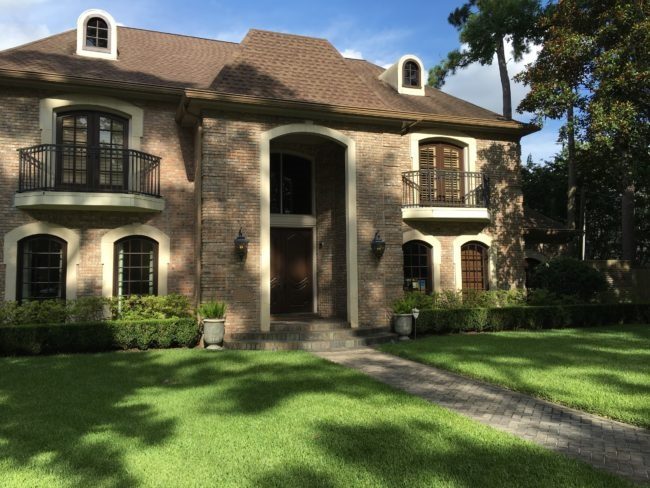 Before the exterior home facelift using Segreto limewash treatment — dramatic transformation of brick facade