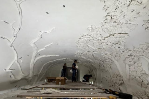 Sculptural plaster barrel ceiling installation in progress.