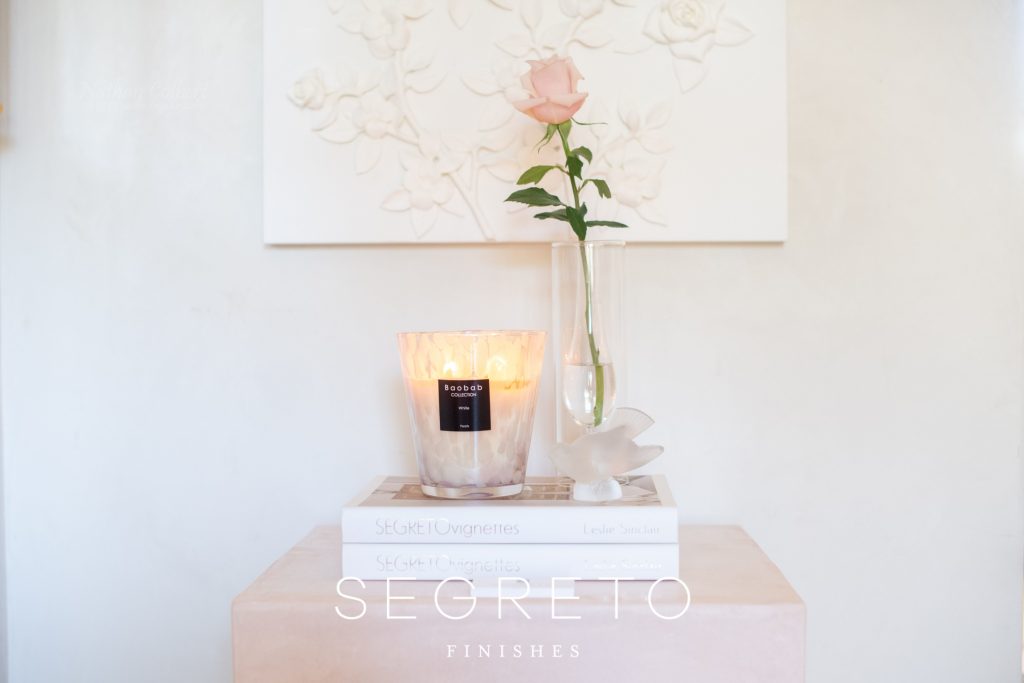 side table with books, candle, & flower on top