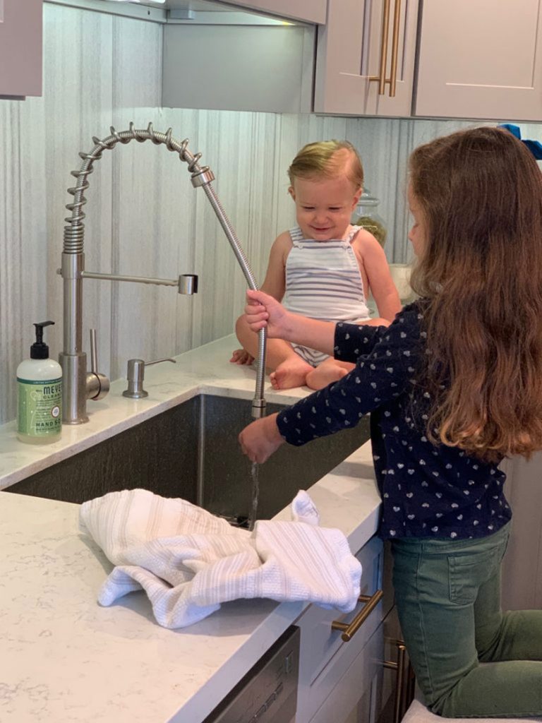 baby watching girl wash hands