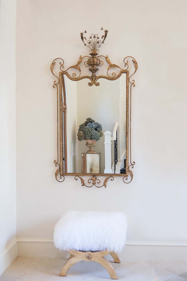 entry with plaster walls and gold antique mirror